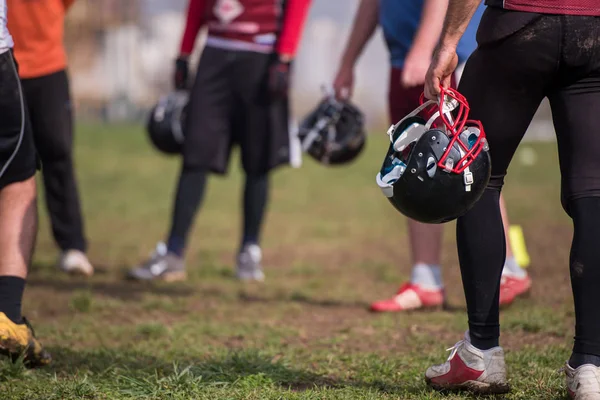 フィールドで黒いヘルメットを保持しているアメリカン フットボール選手のクローズ アップ ショット — ストック写真