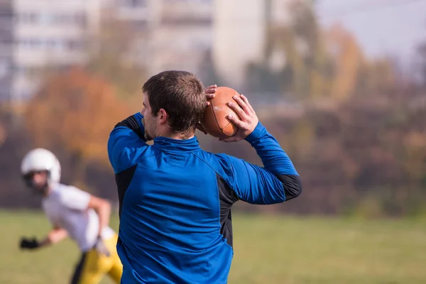 チーム監督はフィールドでのトレーニング中にアクションで若いアメリカのサッカー選手のグループにボールを投げます — ストック写真