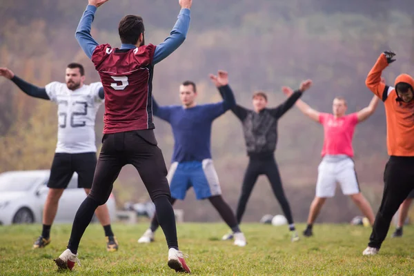 一组年轻的美国足球运动员在练习前一起伸展和热身 — 图库照片