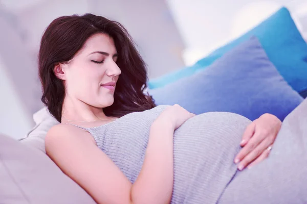 Mladá Šťastná Těhotná Žena Vedení Ruku Břicho Zatímco Sedí Gauči — Stock fotografie