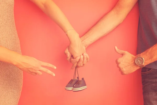 Young Pregnant Couple Holding Newborn Baby Shoes — Stock Photo, Image