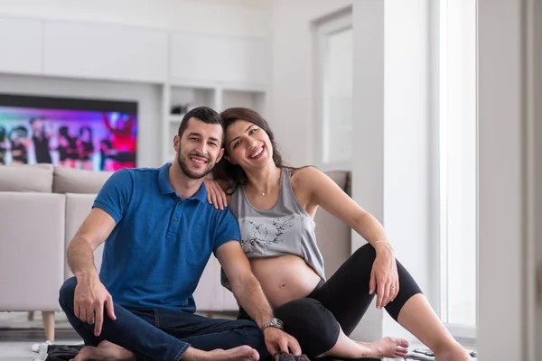幸せな妊娠中のカップルが床の上に胎児の赤ちゃんを自宅のもののリストをチェック — ストック写真