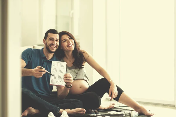 Casal Feliz Grávida Verificando Uma Lista Coisas Para Seu Bebê — Fotografia de Stock