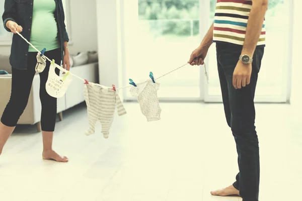 Beautiful Pregnant Woman Her Husband Expecting Baby Holding Baby Bodysuits — Stock Photo, Image