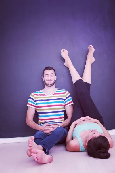 幸せな妊娠中のカップルの家の床に黒い黒板の前でリラックス — ストック写真