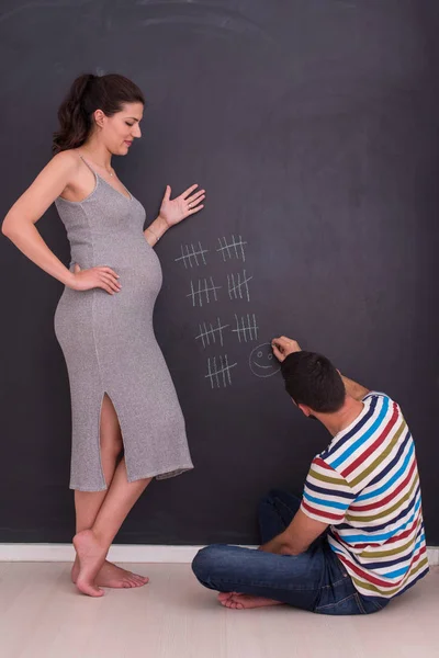 Junges Schwangere Paar Bilanziert Schwangerschaftswoche Und Schreibt Sie Mit Kreide — Stockfoto