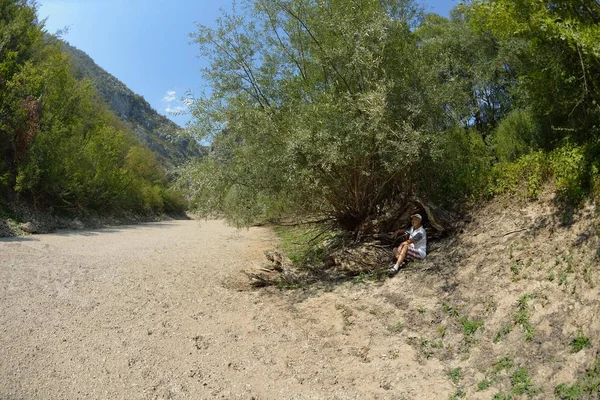 上級男性ハイカー乾燥した川床の渓谷に美しい夏の日にツアーを歩きながら自然でリラックス — ストック写真