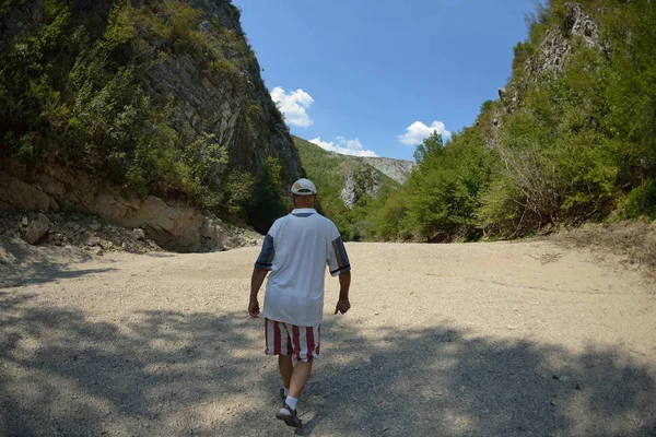 在干燥的河床峡谷上 在美丽的夏日徒步游览时 在大自然中放松身心的海岸男性徒步者 — 图库照片