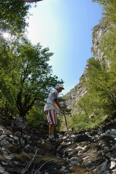 在干燥的河床峡谷上 在美丽的夏日徒步游览时 在大自然中放松身心的海岸男性徒步者 — 图库照片