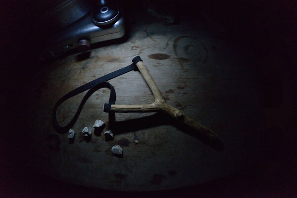 игрушка из рогатки в темноте на деревянном столе
