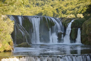waterfall on wild river with fresh drinking water in summer clipart