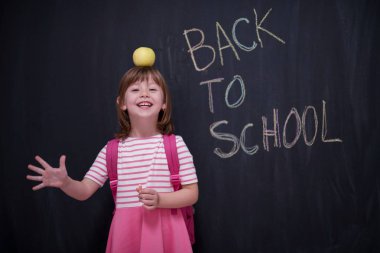 mutlu çocuk ile arka planda kara tahta üzerinde çizim shool için kafasına elma tutan