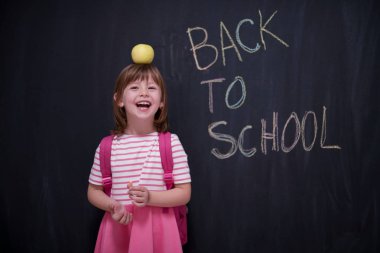 mutlu çocuk ile arka planda kara tahta üzerinde çizim shool için kafasına elma tutan