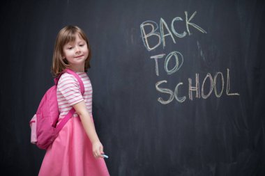 Mutlu okul kız çocuğu geri okula siyah kara tahta yazma sırt çantası ile