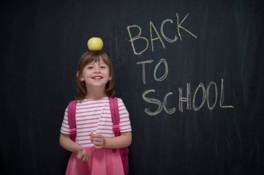 mutlu çocuk ile arka planda kara tahta üzerinde çizim shool için kafasına elma tutan