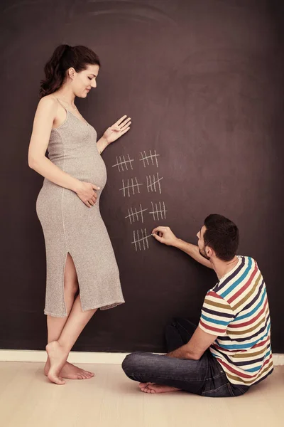 Junges Schwangere Paar Bilanziert Schwangerschaftswoche Und Schreibt Sie Mit Kreide — Stockfoto