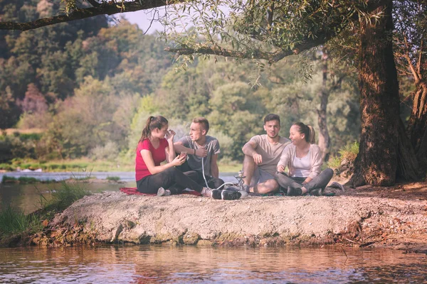 친구들 강가에서 담배를 피우면서 즐긴다 — 스톡 사진
