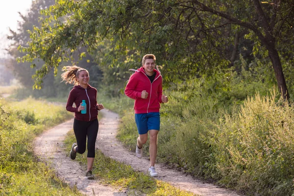 Pareja Joven Disfrutando Estilo Vida Saludable Mientras Trota Largo Camino —  Fotos de Stock