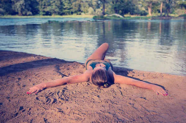 緑のビキニの美しいセクシーな女の子がリラックスして川沿いの自然を楽しむ — ストック写真