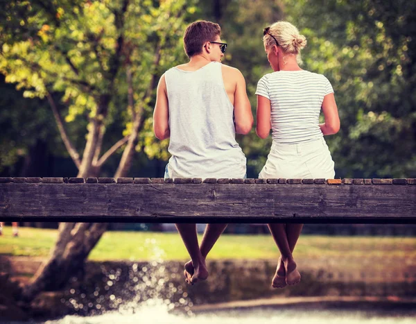 Pareja Enamorada Disfrutando Sandía Mientras Sienta Puente Madera Sobre Río —  Fotos de Stock