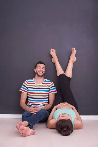 Feliz Casal Grávida Relaxante Frente Quadro Preto Chão Casa — Fotografia de Stock