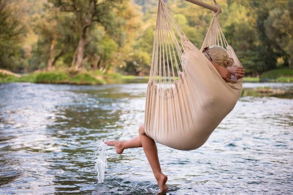 Mladá Blond Žena Odpočívá Houpací Síti Ovívat Přírody Břehu Řeky — Stock fotografie