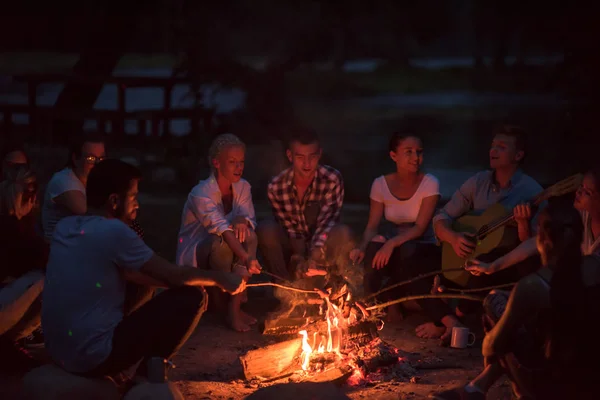 Группа Счастливых Молодых Друзей Отдыхающих Наслаждающихся Летним Вечером Костра Берегу — стоковое фото