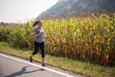 Genç kadın bir ülke road, egzersiz ve fitness kavramı koşu sırasında sağlıklı bir yaşam tarzı zevk