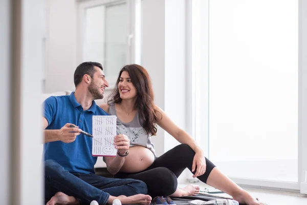 Casal Feliz Grávida Verificando Uma Lista Coisas Para Seu Bebê — Fotografia de Stock