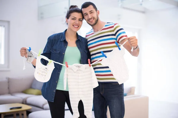 Mooie Zwangere Vrouw Haar Echtgenoot Verwachten Baby Baby Bodysuits Houden — Stockfoto