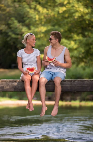 Verliebte Paare Genießen Wassermelone Während Sie Auf Der Holzbrücke Über — Stockfoto