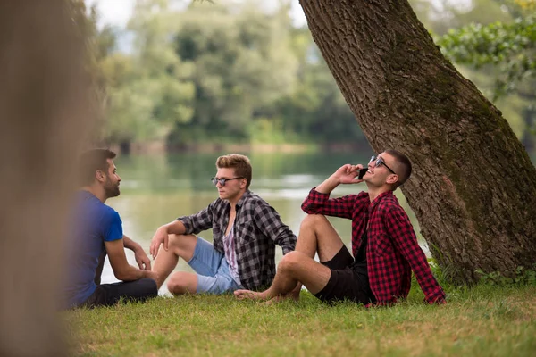 Grupo Jovens Apreciando Natureza Sentado Margem Rio — Fotografia de Stock