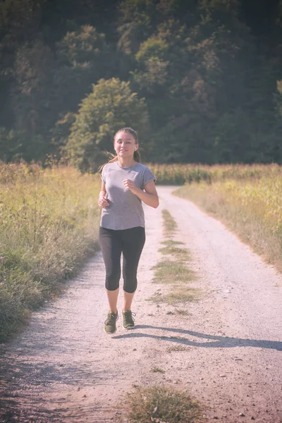 Młoda Kobieta Korzystających Zdrowego Trybu Życia Podczas Joggingu Wzdłuż Kraju — Zdjęcie stockowe