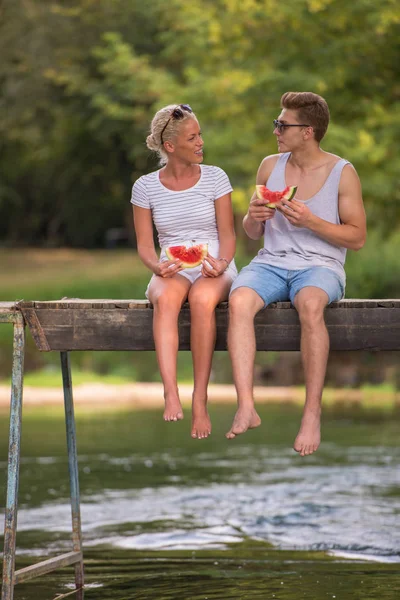 Verliebte Paare Genießen Wassermelone Während Sie Auf Der Holzbrücke Über — Stockfoto
