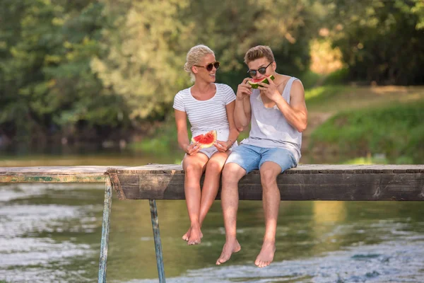 Verliebte Paare Genießen Wassermelone Während Sie Auf Der Holzbrücke Über — Stockfoto