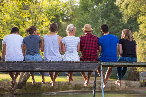 Grupo Jóvenes Amigos Disfrutando Sandía Mientras Están Sentados Puente Madera — Foto de Stock