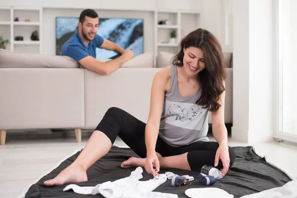 幸せな妊娠中のカップルが床の上に胎児の赤ちゃんを自宅のもののリストをチェック — ストック写真
