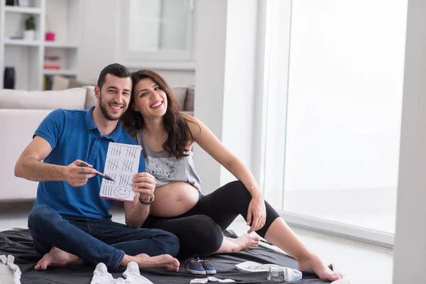 Casal Feliz Grávida Verificando Uma Lista Coisas Para Seu Bebê — Fotografia de Stock