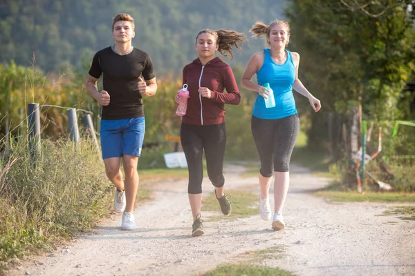 Grupa Młodych Ludzi Jogging Podismo Drogowego Kraju Działa Otwartej Drodze — Zdjęcie stockowe