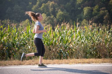 Genç kadın bir ülke road, egzersiz ve fitness kavramı koşu sırasında sağlıklı bir yaşam tarzı zevk