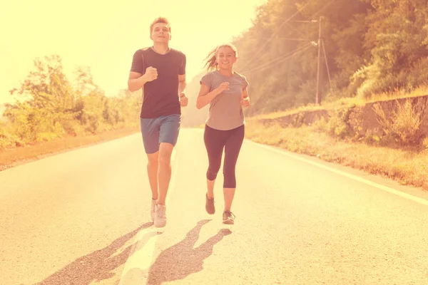 年轻夫妇一边在乡间小径上慢跑一边享受健康的生活方式 运动和健身的概念 — 图库照片