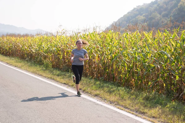 Genç kadın bir ülke road, egzersiz ve fitness kavramı koşu sırasında sağlıklı bir yaşam tarzı zevk
