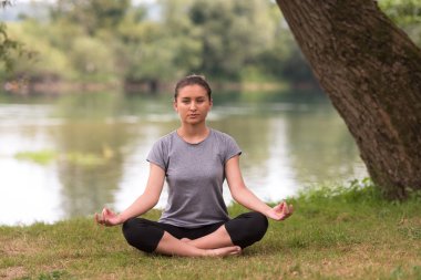 sağlıklı kadın meditasyon ve yoga yaparken Nehri kıyısında güzel doğada egzersiz yaparken rahatlatıcı