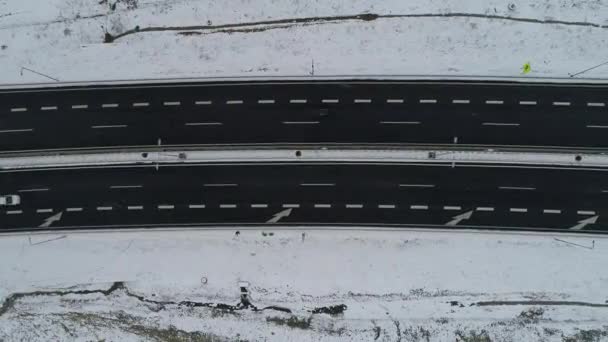 雪の降る冬の日のトラフィックの少ない高速道路の上空のトップ表示 — ストック動画