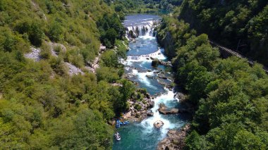 bir grup insan beyaz su aktivite şelale ile vahşi Nehri'nde rafting yapıyor