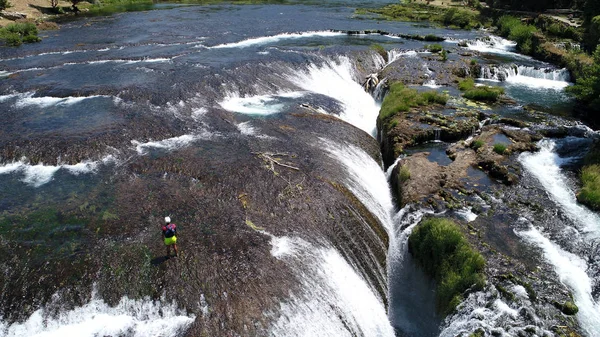 一群人在有瀑布的野生河流上进行白水漂流活动 — 图库照片