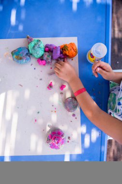 Çocuk renkli kil ile oynarken ellerini