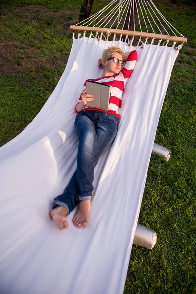 Jovem Mulher Usando Computador Tablet Enquanto Relaxa Rede Jardim Tranquilo — Fotografia de Stock