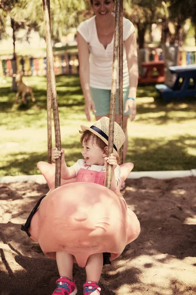 Ung Mamma Och Hennes Lilla Dotter Ler Tillsammans Medan Swinging — Stockfoto