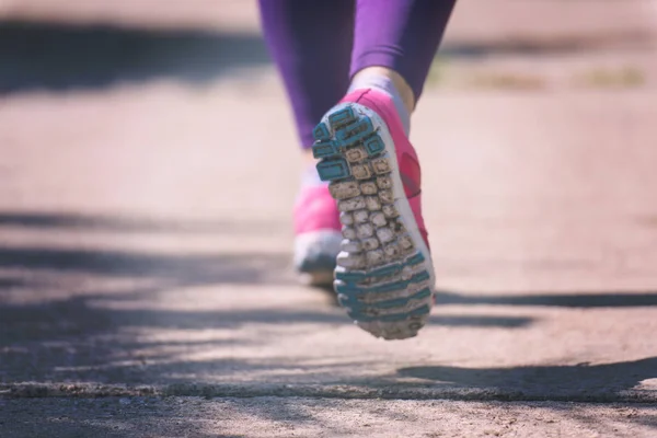 若いスポーティな女性ランナーの晴れた朝の美しい熱帯公園でマラソンのトレーニング — ストック写真